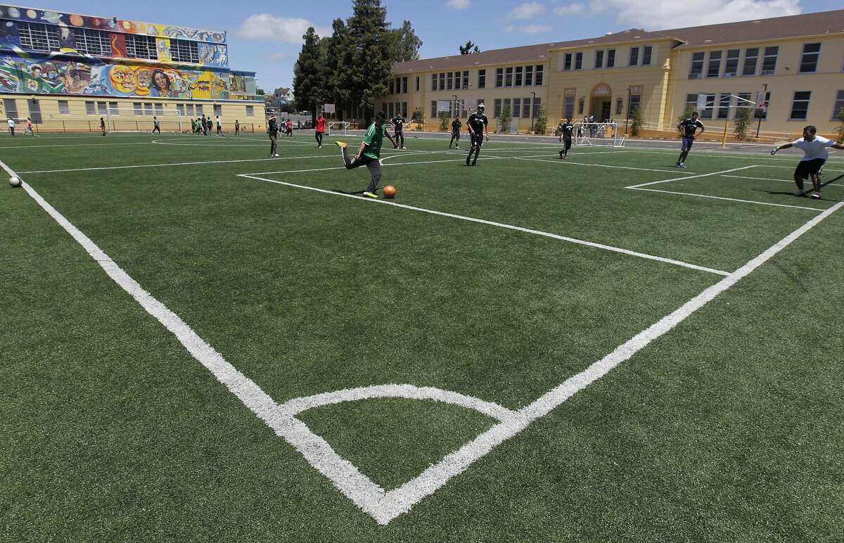 Students play soccer on a new field at Life Academy High School in Oakland, Calif. on Thursday, June 27, 2014. Former students raised $500,000 to build the field, which has become a centerpiece of the Fruitvale District.