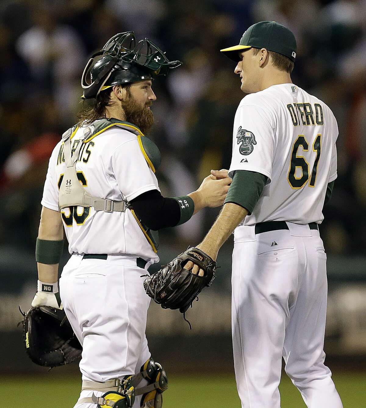 Oakland Athletics' Derek Norris, left, and Dan Otero (61) celebrate after the 4-2 defeat of the Boston Red Sox at the end of a baseball game Thursday, June 19, 2014, in Oakland, Calif. (AP Photo/Ben Margot)