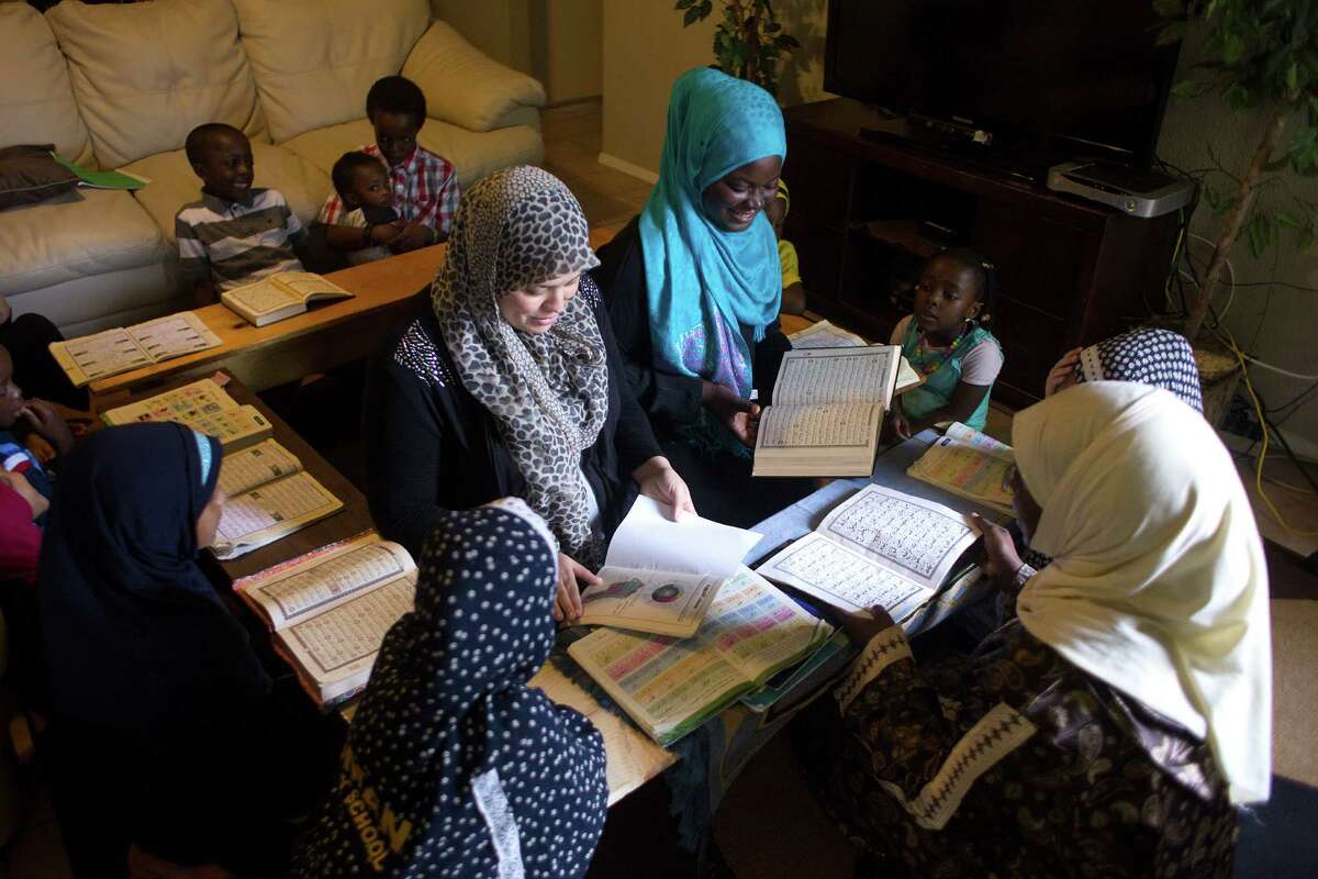 Surrounded by students, Amina Meliani, center left, and Sofiyyah Abdulwahab, center right, recite sections of the Quran for teacher Zenab Hamdan.