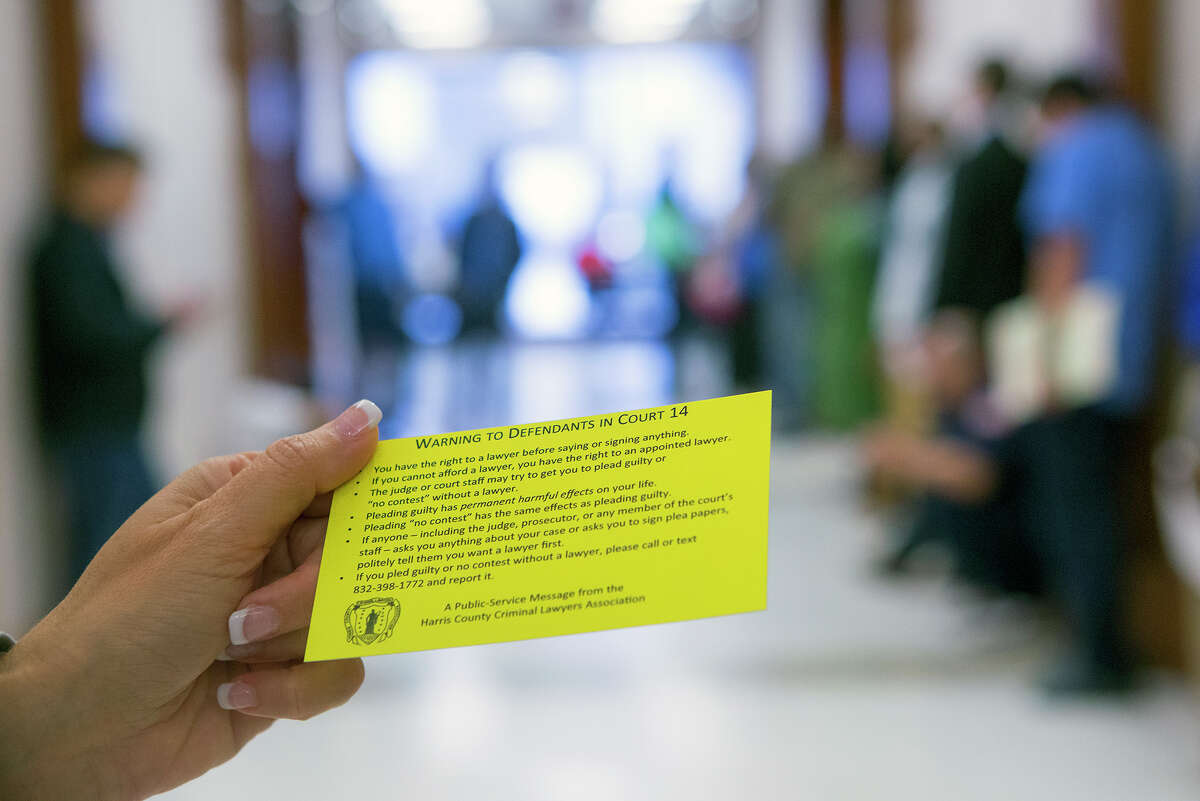 Attorney JoAnne Musick holds a flyer at the Harris County Criminal Courthouse, Friday, June 27, 2014, in Houston. The flyer advised defendants that a judge may be violating their constitutional rights by not appointing attorneys to their cases.