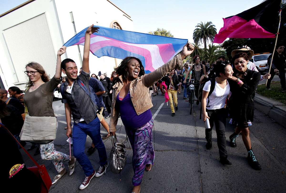 Ms. Jajah Desmon, center, of San Francisco, and Anthony Escobar, left, and Audrey Vogel, far left, both of Berkeley, carry a flag during Trans March 2014 in San Francisco, Calif., on Friday, June 27, 2014.