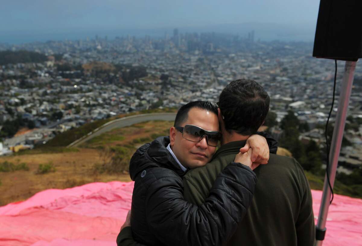 Bill Gardnev embraces Joe Lesca above the pink triangle at Twin Peaks on June 28, 2014 in San Francisco, CA. The Pink Triangle, symbol of the oppression of LGBT people, was built on Twin Peaks Saturday in recognition of the pride celebration.