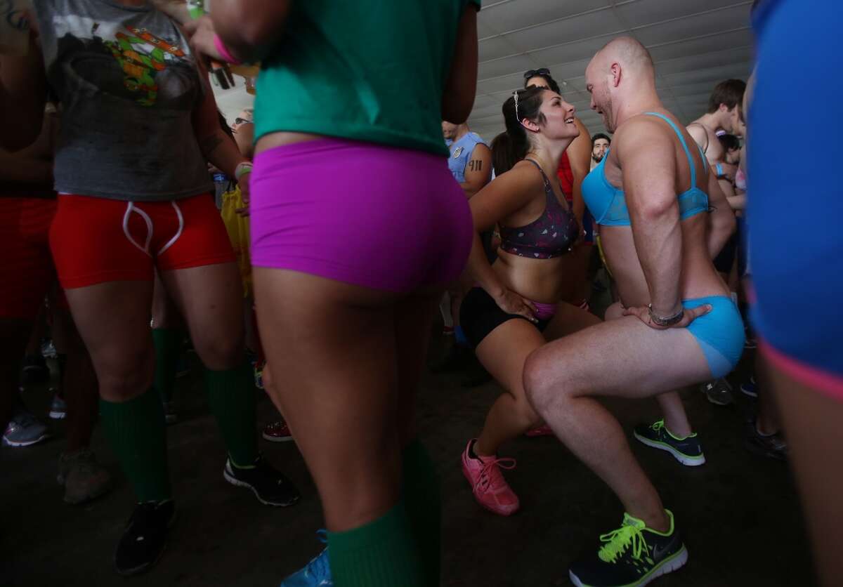 Sarah Day and Matt Bradshaw stretch out while dancing during the pre-party Hot Undies Run on June 28, 2014, in Houston, Tx. The Hot Undies Run charity event started at the Gorgeous Gael Pub in Rice Village. ( Mayra Beltran / Houston Chronicle )
