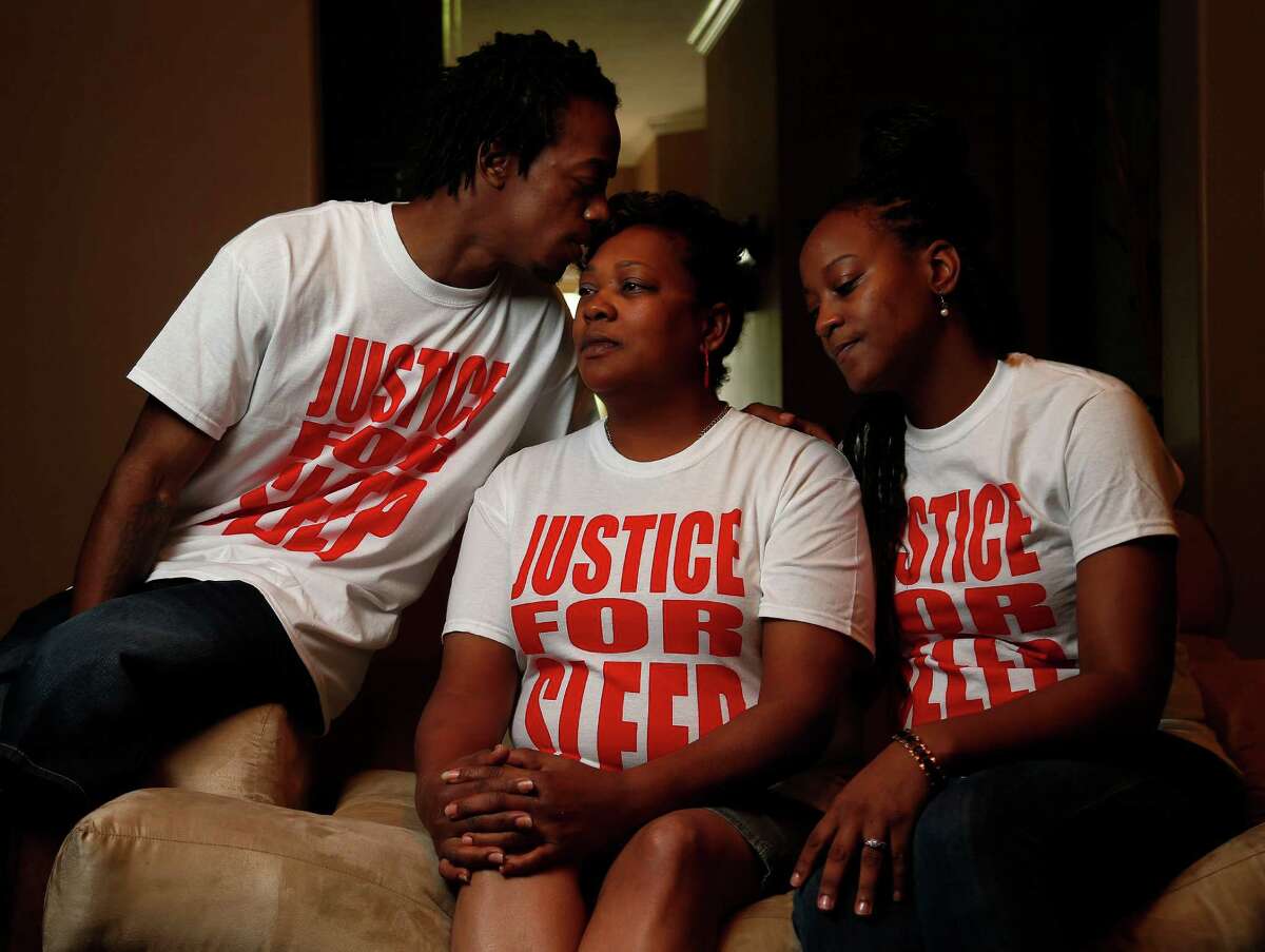 Margaret Pink-Green, flanked by her son Ellis and daughter Erika Pink, says she would like "some closure" in the homicide of her eldest child, Eric, whose nickname was "Sleepy." They're wearing T-shirts emblazoned with "Justice for Sleep" in his honor.