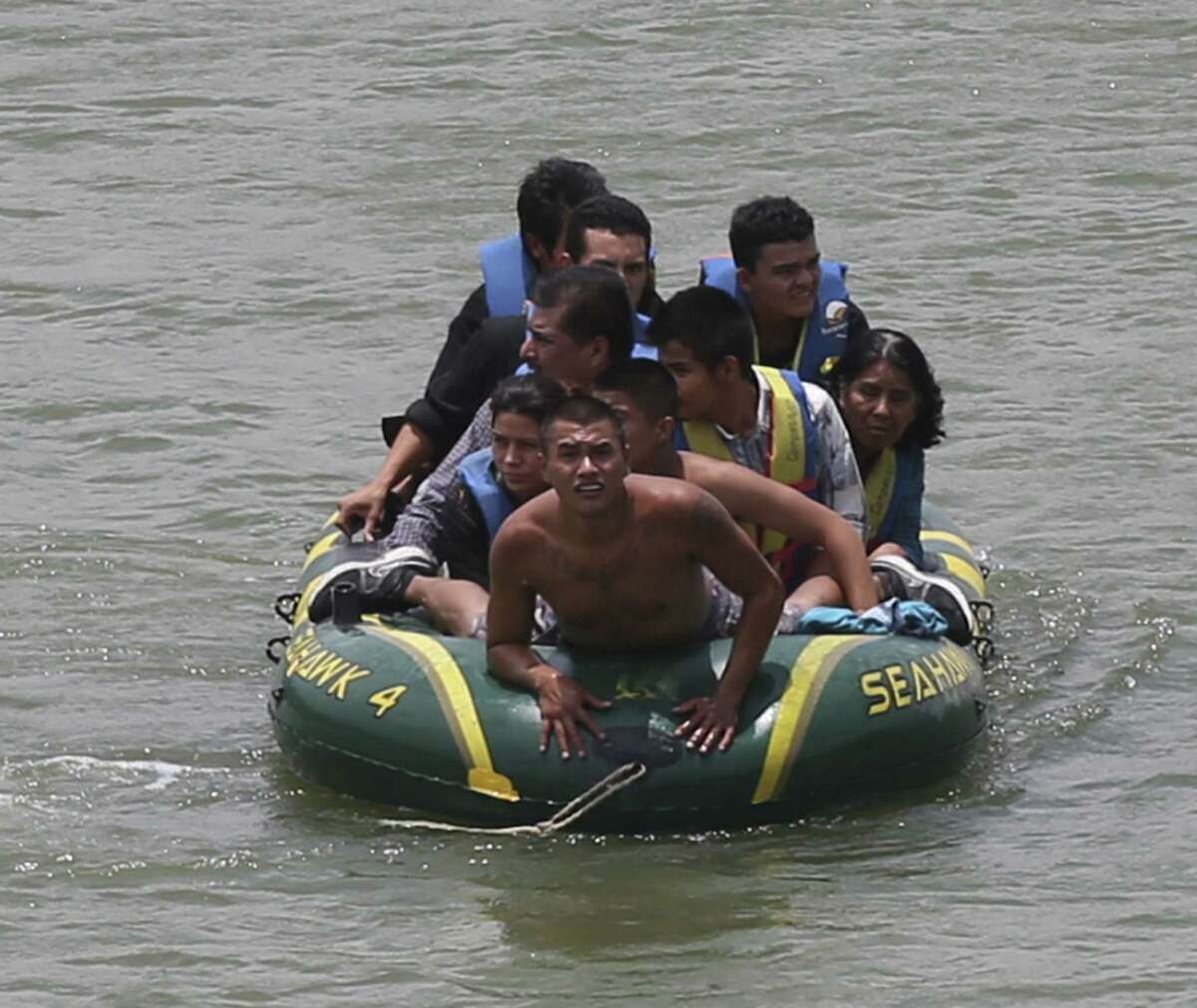 Using an inflatable raft, smugglers, carry immigrants across the Rio Grande near the international bridge in Roma. Law officials say higher-risk smuggling operations are moving into Starr County to avoid areas now saturated with officers.