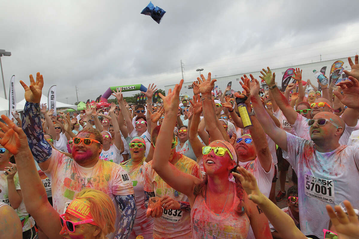 Participants reach for a bag of dyed cornstarch during the "Color Me Rad," 5K race at the Freeman Coliseum, Sunday, June 29, 2014. Part of the proceeds went to the Ronald McDonald House.