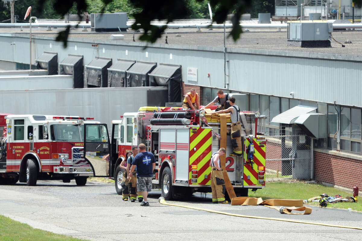Firefighters clean up after responding to a call at Latex International, in Shelton, Conn. June 30, 2014.