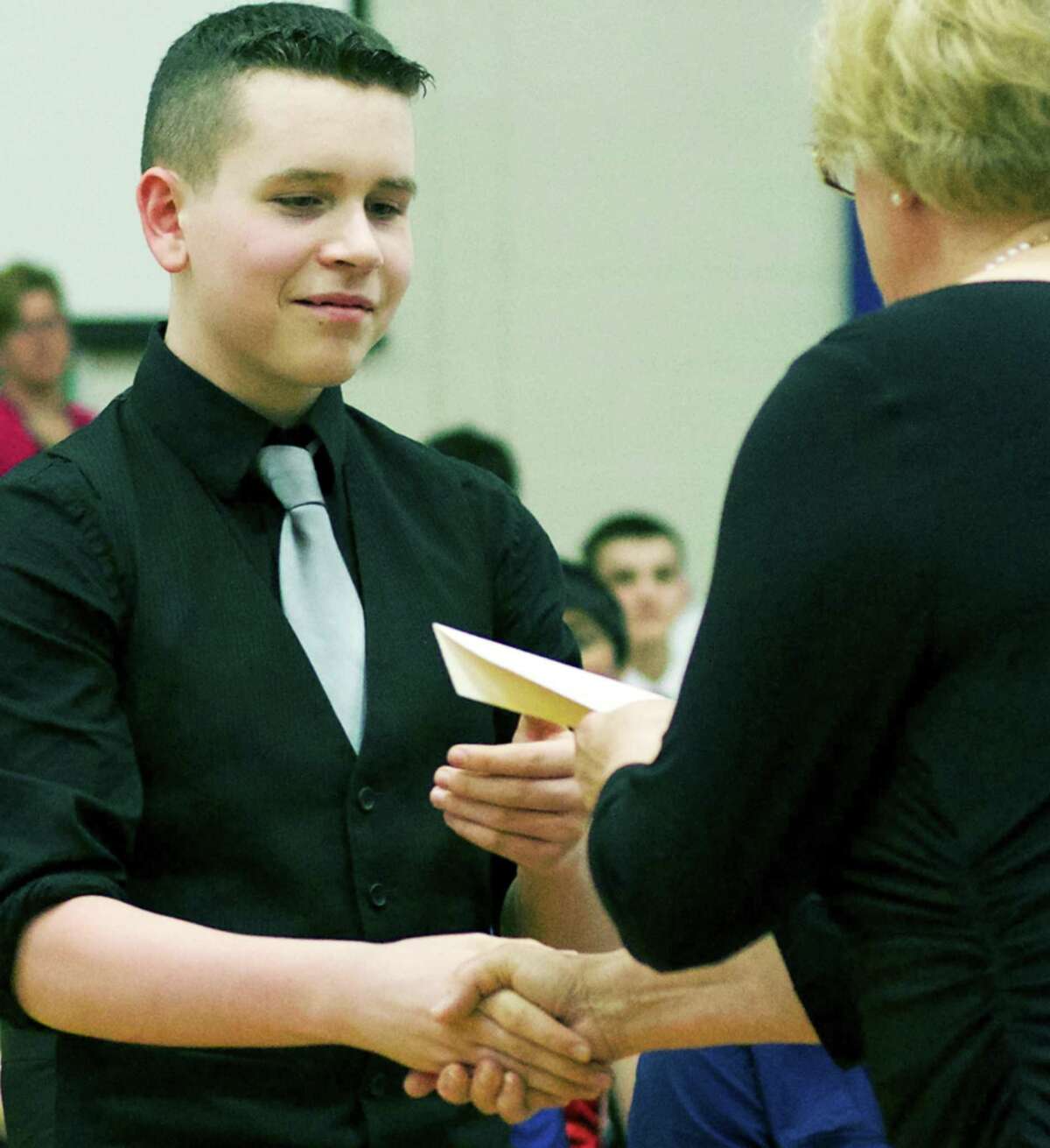 Dominic Adams receives his certificate of promotion from Principal Dana Ford during the White team's promotion ceremony June 16, 2014 at Schaghticoke Middle School in New Milford.