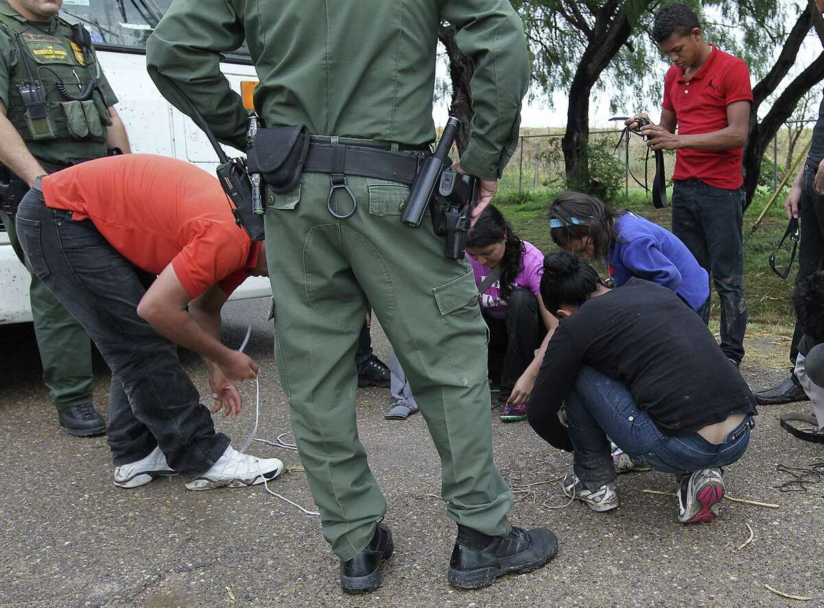U.S. Border Patrol agents detain immigrants in Granjeno. A surge of unaccompanied minors is causing political headaches.