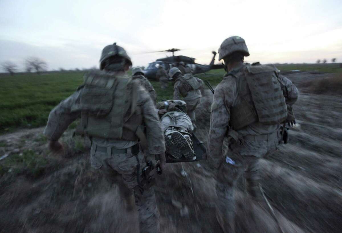 During a medevac mission by the Army's Task Force Pegasus, Marines carry a wounded comrade to a helicopter in Afghanistan. Charles Kelly helped prove the lifesaving value of dedicated evacuation helicopters in battle.