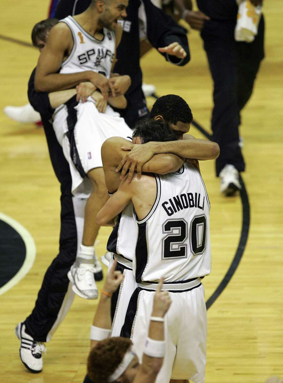 Beno Udrih lifts Tony Parker as Tim Duncan and Manu Ginobili hug after the Spurs' 81-74 victory over the Pistons in Game 7 of the 2005 NBA Finals.
