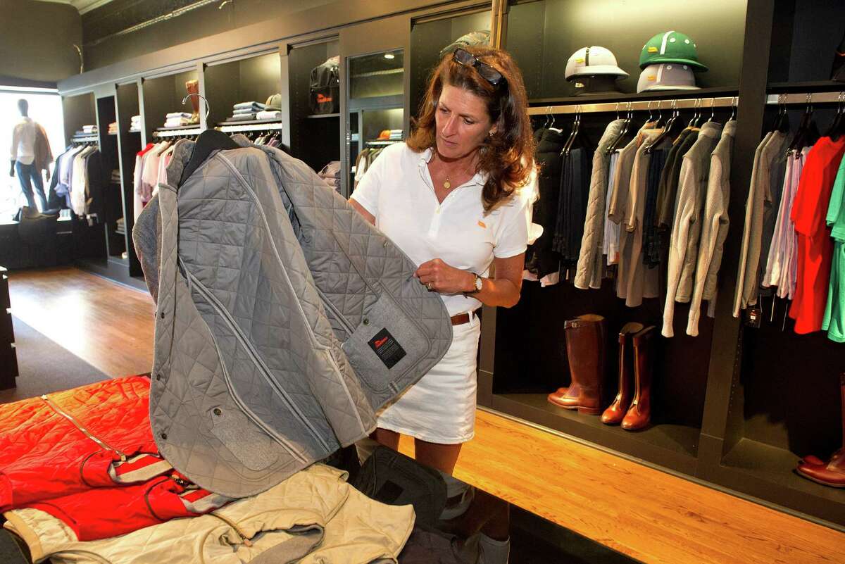 Store manager Leslie Shantz shows the craftmanship in the inside of a jacket at the newly opened Casablanca store on Greenwich Avenue in Greenwich, Conn., on Tuesday, July 1, 2014. The store sells equipment for polo players, including helmets, boots, and mallets, as well as luxury clothing.