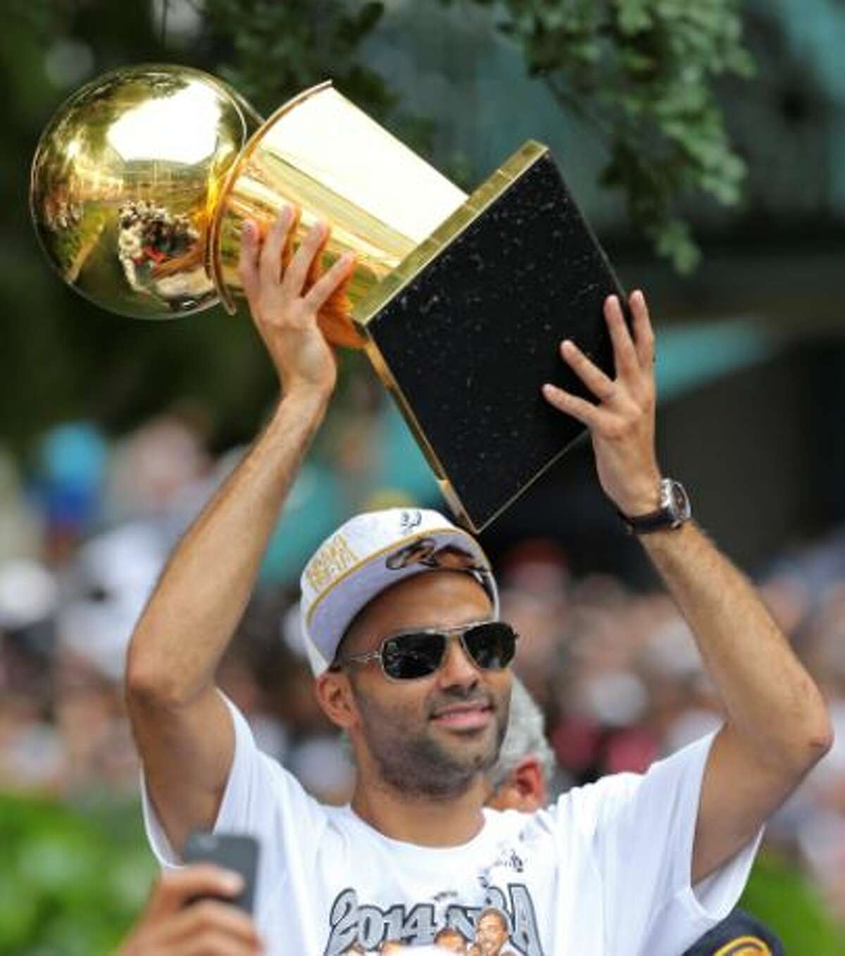 Tony Parker holds one of the five Larry O'Brien trophies the Spurs have won duirng the Championship Celebration on the River Walk.
