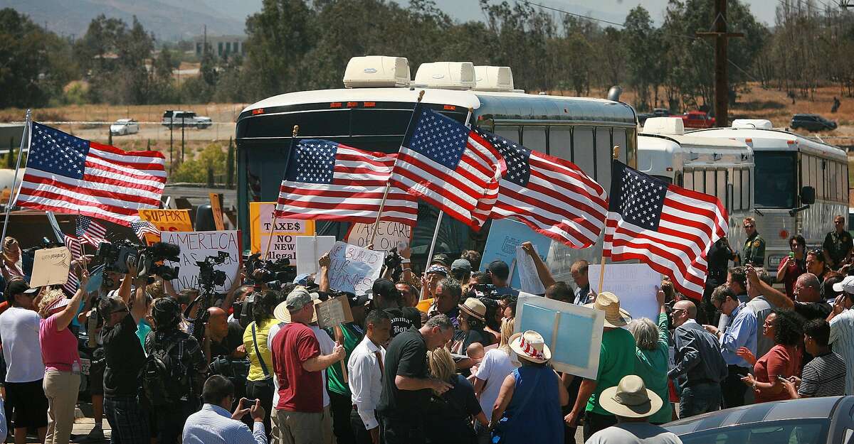 Protesters turn back three buses carrying 140 immigrants as they attempt to enter the Murrieta U.S. Border Patrol station for processing on Tuesday, July 1, 2014, in Murrieta, Calif.(AP Photo/The Press-Enterprise, David Bauman) MAGS OUT; MANDATORY CREDIT