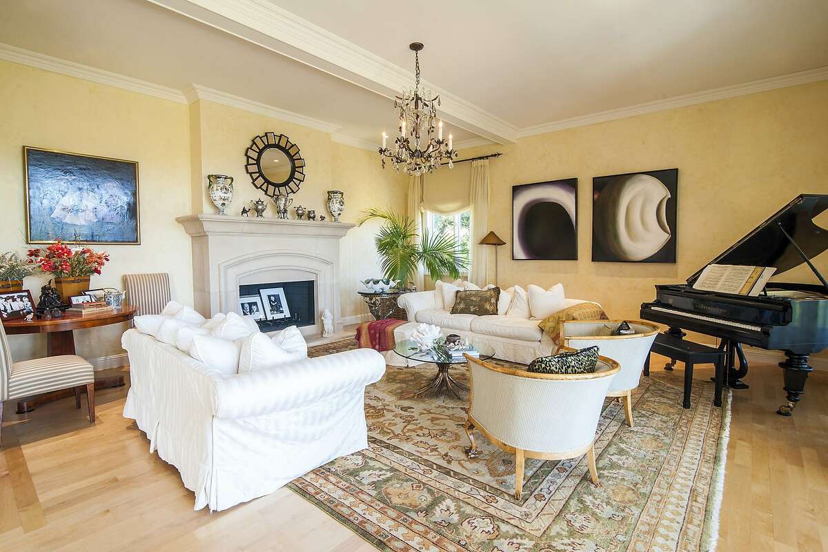 The living room includes a fireplace, contemporary chandelier and gallery walls for displaying artwork.
