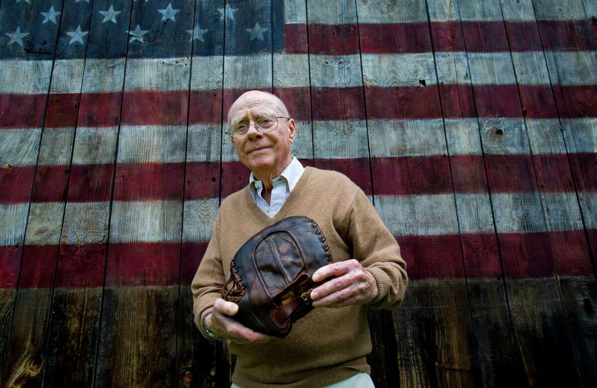 Howard Henderson, who as a boy in New York played catch with baseball legend Lou Gehrig, holds a signed baseball mitt given to him by Gehrig when he was young, near Henderson's Greenwich, Conn., home on Monday June 30, 2014. Gehrig, a Yankee first baseman and a friend of Henderson's songwriter father, visited his home and Henderson visited him when he had ALS. The mitt, that was autographed by Gehrig with a hot instrument, will be auctioned in July, expecting to fetch $200,000 to $300,000.