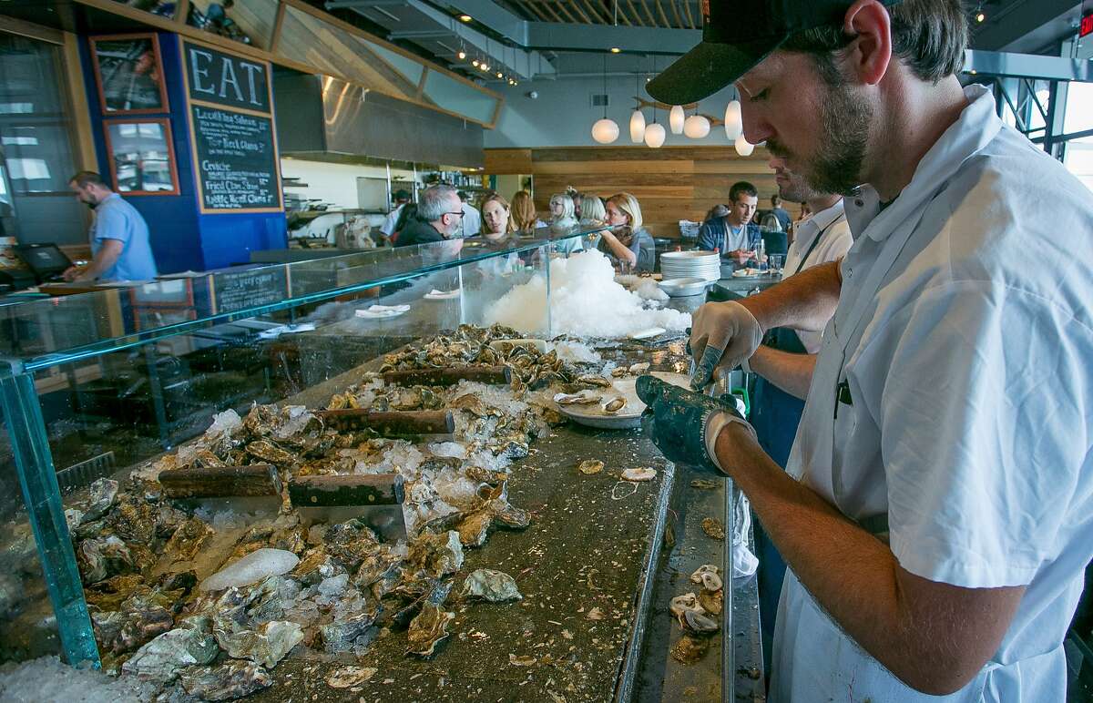 Ethan Thompson shucks oysters at Hog Island in San Francisco, Calif., on Wednesday, July 2nd, 2014.