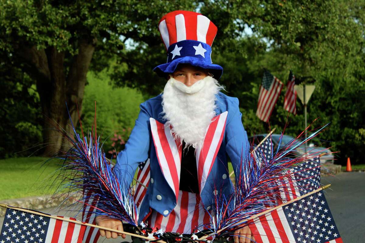 Locals hit Olmos Park to brandish banners, wear funny hats, wave flags, wish America a happy birthday and celebrate freedom from the British.