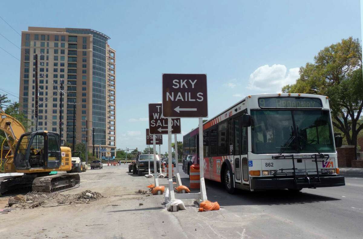 A bus drives by signs announcing entrances to businesses in the construction zone along Broadway near Hildebrand on July 3, 2014. The work on drainage and traffic flow improvements has been ongoing for more than one year. .