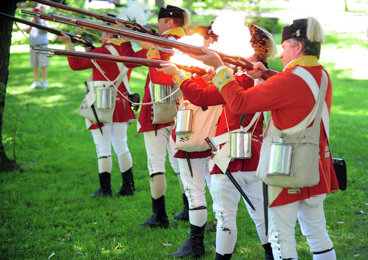 Revolutionary War re-enactors with the British Seventh Company of the Ninth Regiment of Foot, drill around the grounds, during Family Fun Fest held on the Town Hall Green and the Fairfield Museum and History Center in Fairfield, Conn. on Saturday July 5, 2014. The festival featured a full slate of musical entertainment, artisan fair, and games and activities for children.