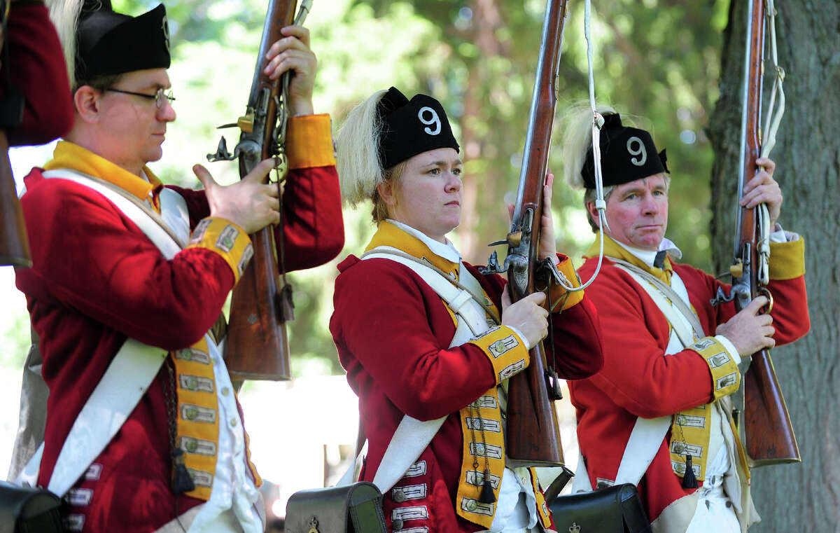 Revolutionary War re-enactors with the British Seventh Company of the Ninth Regiment of Foot, drill around the grounds, during Family Fun Fest held on the Town Hall Green and the Fairfield Museum and History Center in Fairfield, Conn. on Saturday July 5, 2014. The festival featured a full slate of musical entertainment, artisan fair, and games and activities for children.