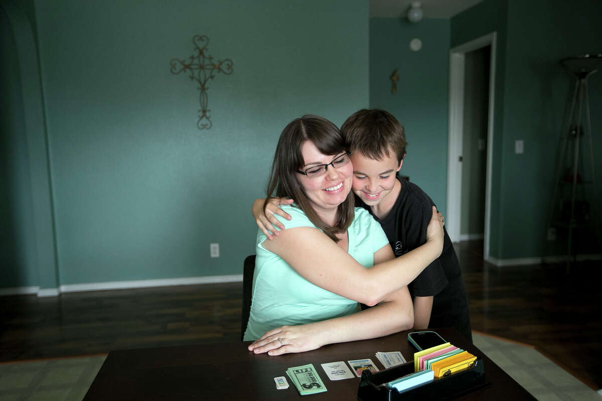 Nicole Benham hugs her son Andrew, 10, at their Hutto, Texas, home on May 24, 2014. Called a gestational carrier or gestational surrogate because neither baby comes from her own eggs, Benham is among hundreds of American women who carry babies for family, friends and strangers each year. (AP Photo/Austin American-Statesman, Deborah Cannon) AUSTIN CHRONICLE OUT, COMMUNITY IMPACT OUT, INTERNET MUST CREDIT PHOTOGRAPHER AND STATESMAN.COM