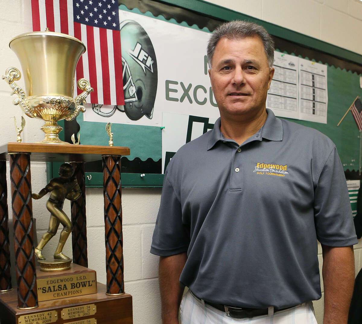 Michael Inco, Kennedy High School's new athletic director and head football coach, poses Thursday with the Salsa Bowl trophy the Rockets won last year.