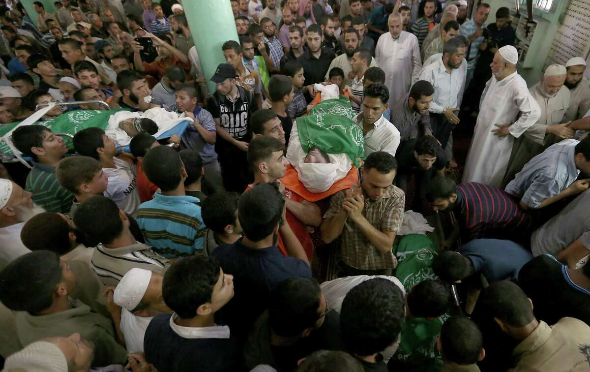 Palestinians carry bodies of the Ezz Al-Din Al Qassam Brigades members who were killed in an airstrike during a funeral in Rafah, southern Gaza Strip on Monday, July 7, 2014. The Islamic militant group Hamas that rules Gaza vowed revenge on Israel for the death of several of its members killed in an airstrike early Monday morning in the deadliest exchange of fire since the latest round of attacks began weeks ago. (AP Photo/Hatem Moussa)