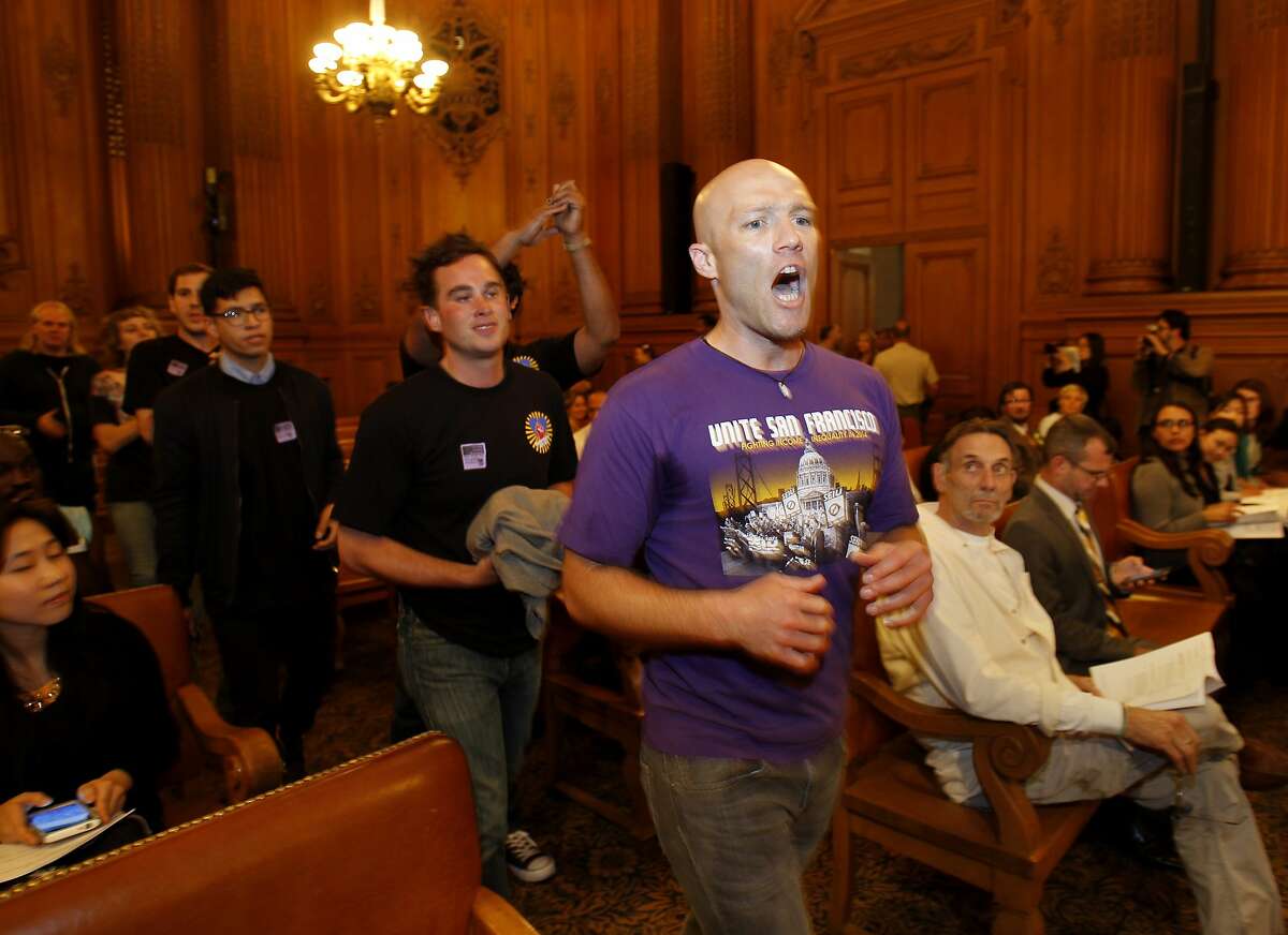 SEIU members including Carey Dall and their supporters marched through the Board of Supervisors meeting before it started Tuesday July 8, 2014. Members of the SEIU protested at the San Francisco Board of Supervisors meeting over the amount paid nonprofit service agencies in the city.