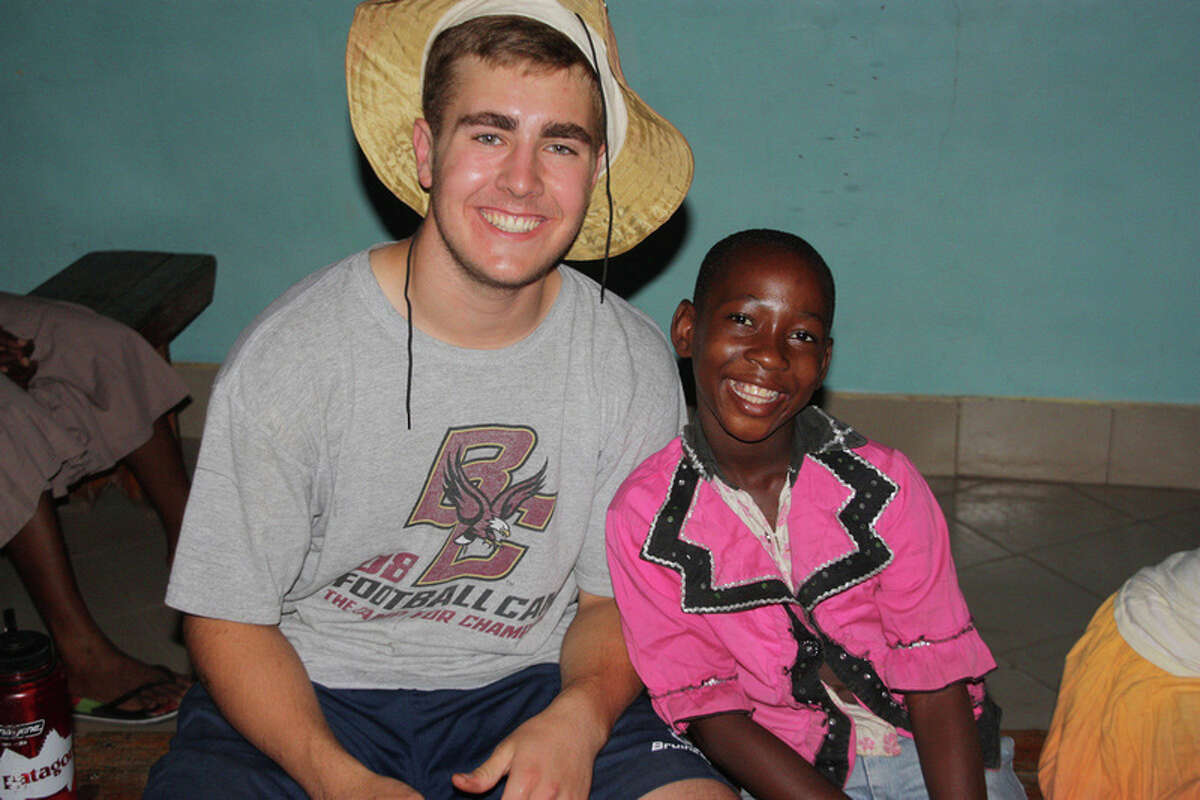 Brunswick School student Jamie MacFarlane of Greenwich shares a smile with a Tanzanian orphan girl. MacFarlane was one of four Brunswick students who traveled to the East African country in June to volunteer at an orphanage for more than 40 girls, ages 8 to 15.