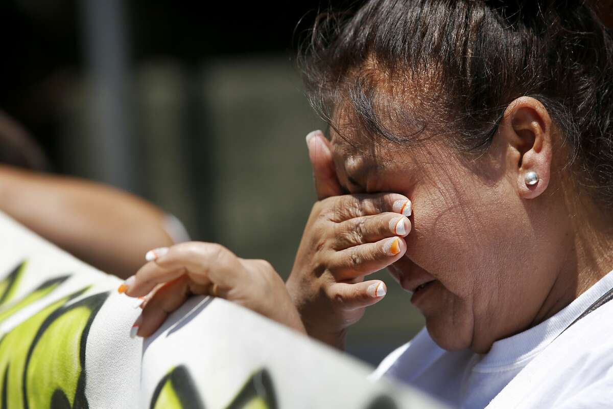 Lurdes Olvera, the godmother of Andy Lopez, sheds tears while holding a sign during a protest July 8, 2014 outside of the Sonoma County Hall of Justice in Santa Rosa, Calif. People gathered to protest D.A. Jill Ravitch to let her know that they are unhappy with the lack of charges in the case involving the death of Andy Lopez last year.