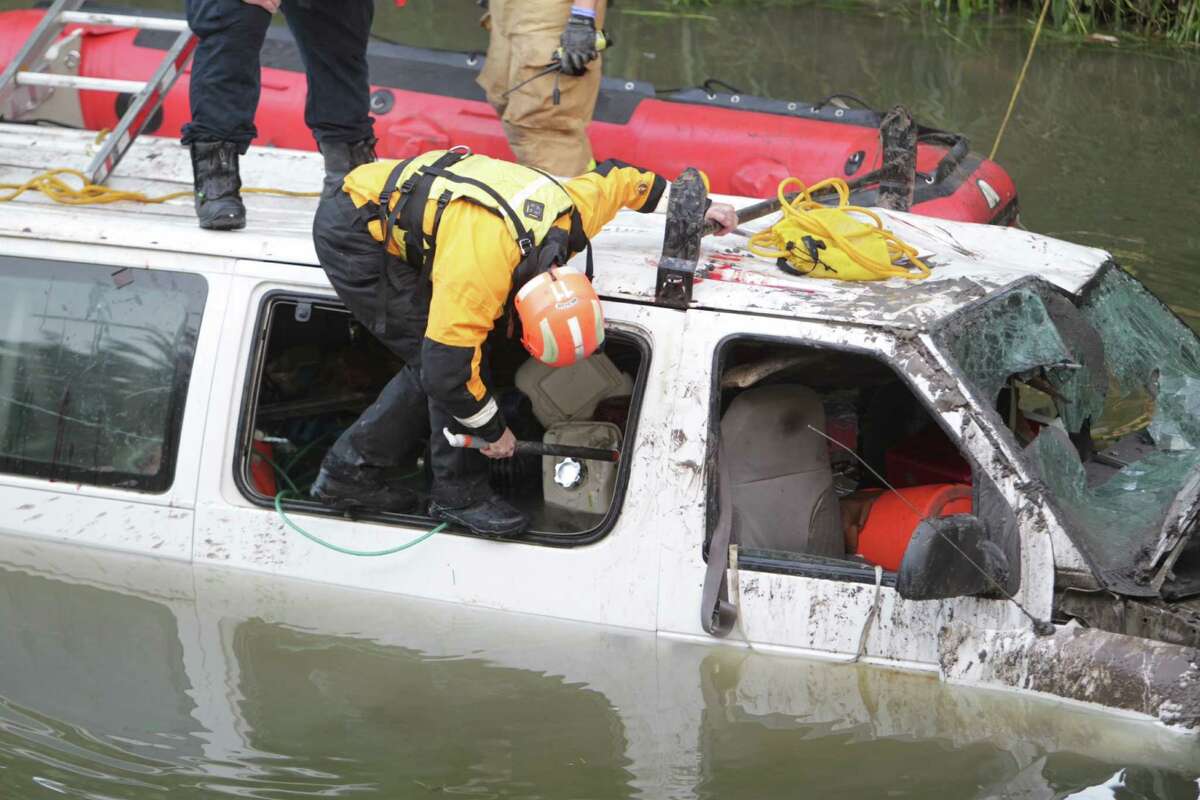 Houston emergency crews worked to rescue seven men trapped in a white van that plunged off the bridge and landed in a bayou near Cavalcade and North Freeway early Wednesday morning.