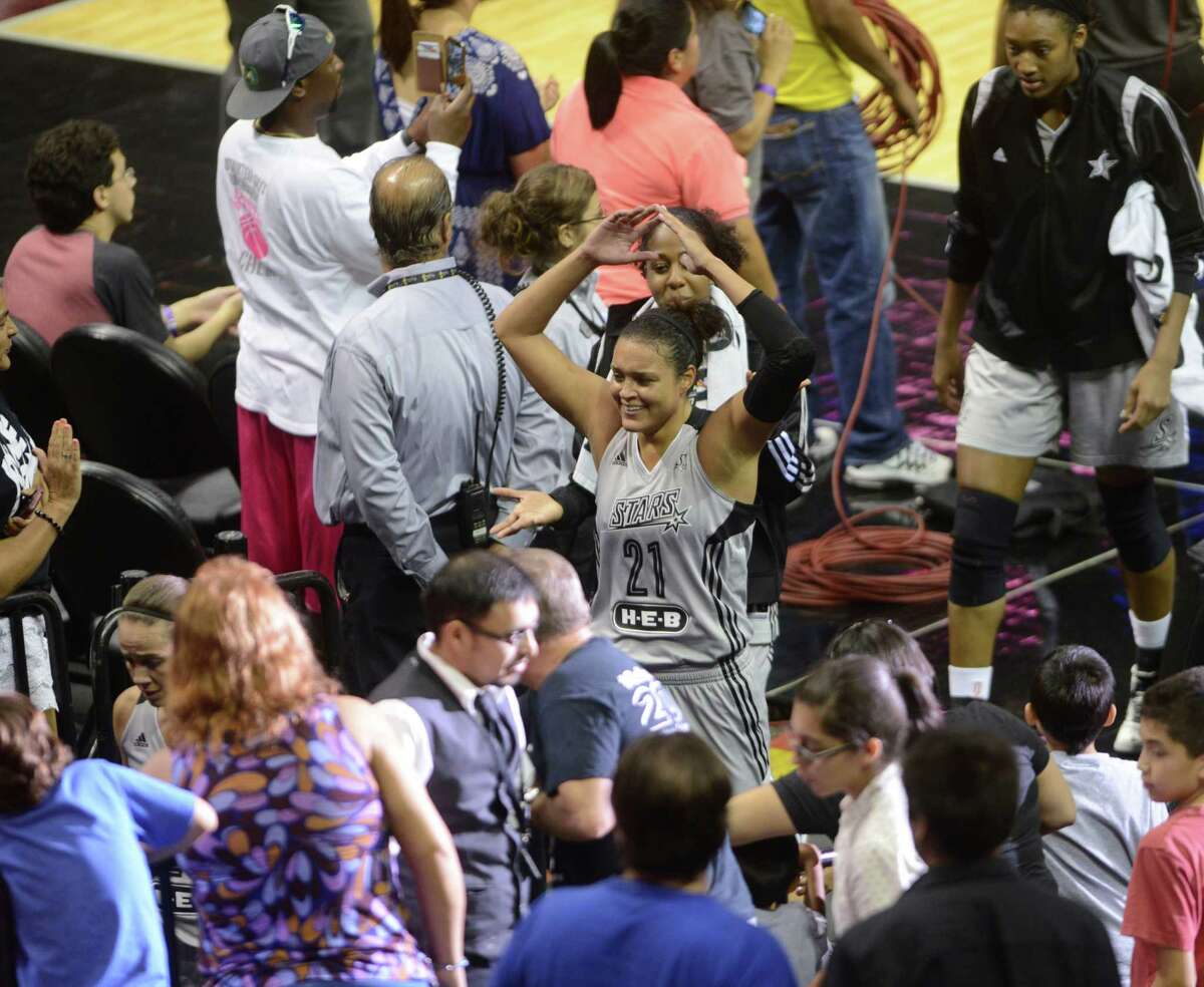 Kayla McBride of the San Antonio Stars greets fans as she leaves the court for halftime during WNBA action against the New York Liberty in the AT&T Center on Wednesday, July 9, 2014.
