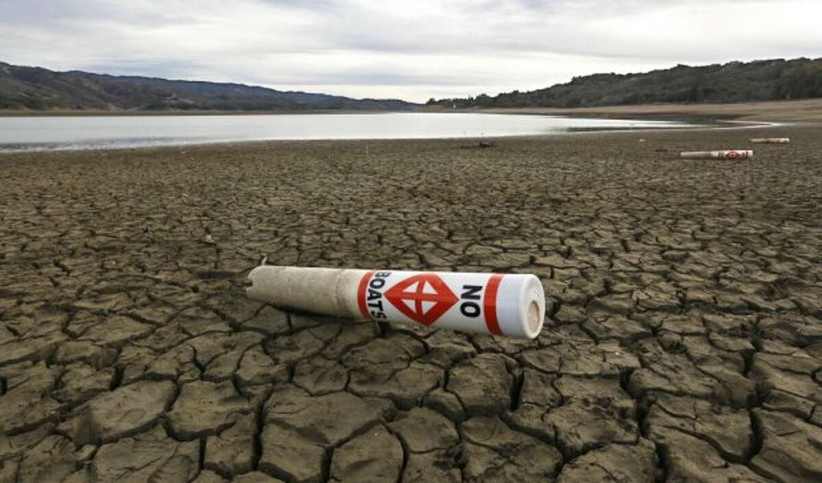 In this file photo, a warning buoy sits on the dry, cracked bed of Lake Mendocino near Ukiah, Calif. The Legislature has placed a  $7.5 billion water bond measure that is scheduled to go before voters in November. 