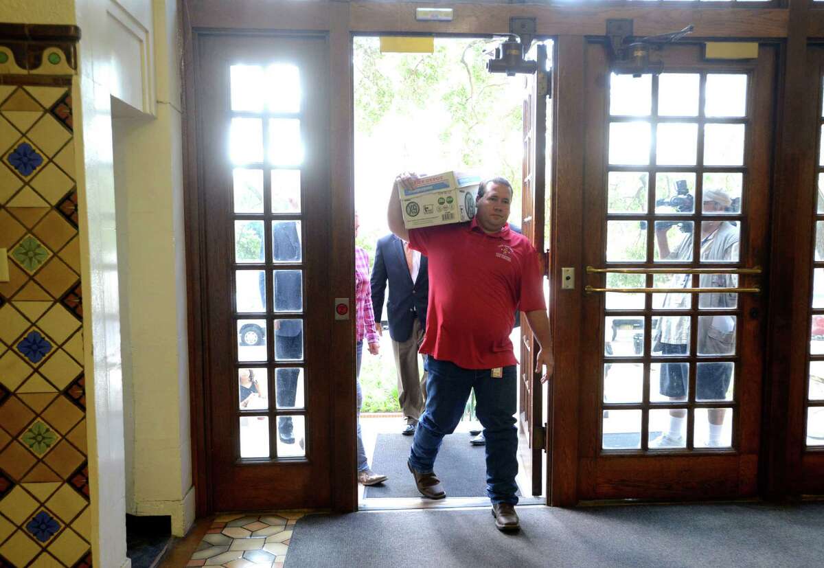 Stephen Moody carries a box containing signatures on petitions to the city clerk's office on Tuesday morning, July 8, 2014.