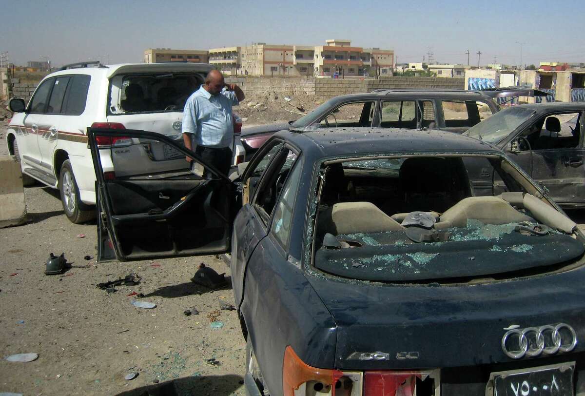 Iraqi citizens inspect the site of a car bomb attack Thursday on vehicles lined up at a gas station in the oil rich city of Kirkuk, 147 miles north of Baghdad.