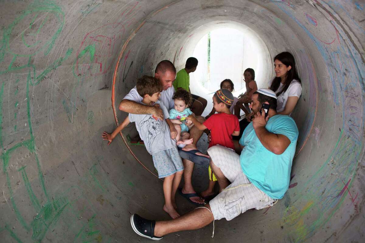 Israelis hide in a large concrete pipe used as a shelter during a Palestinian rocket attack Thursday on the southern Israeli village of Nitzan. The village is mainly inhabited by former Israeli settlers who left the Gaza Strip in 2005.