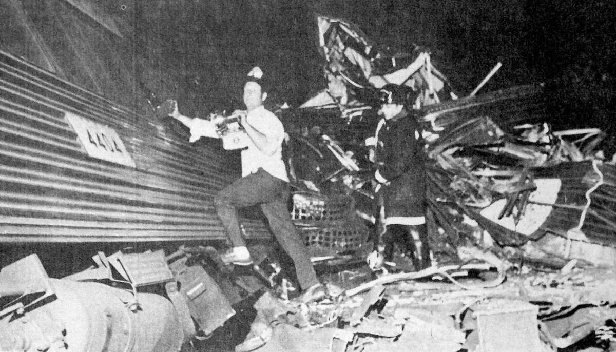 Rescue workers look for survivors following the collision of two Penn Central commuter trains near Hoyt Street in Darien on Aug. 20, 1969. Four people were killed and more than 40 were injured in the accident which prompted calls for increased safety.