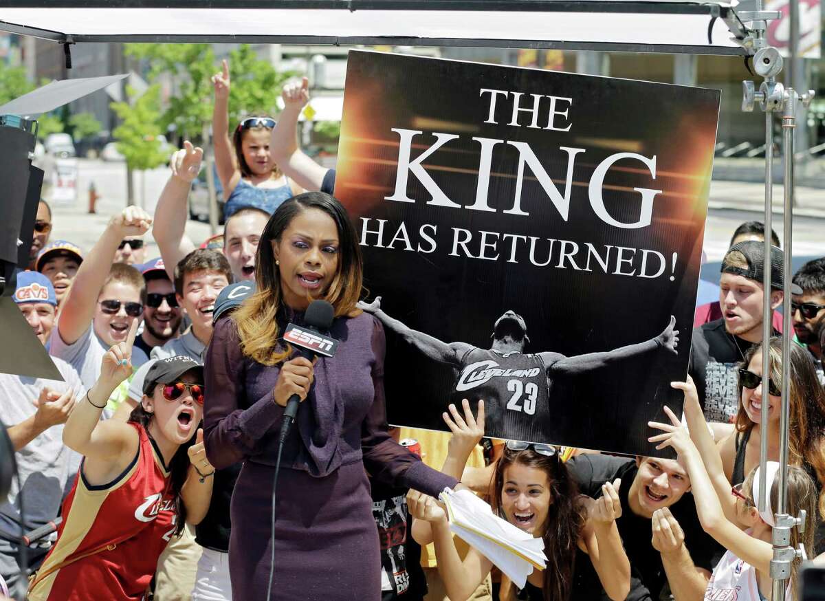 Fans whoop it up behind an ESPN reporter in Cleveland after learning LeBron James would play for the Cavaliers next season.