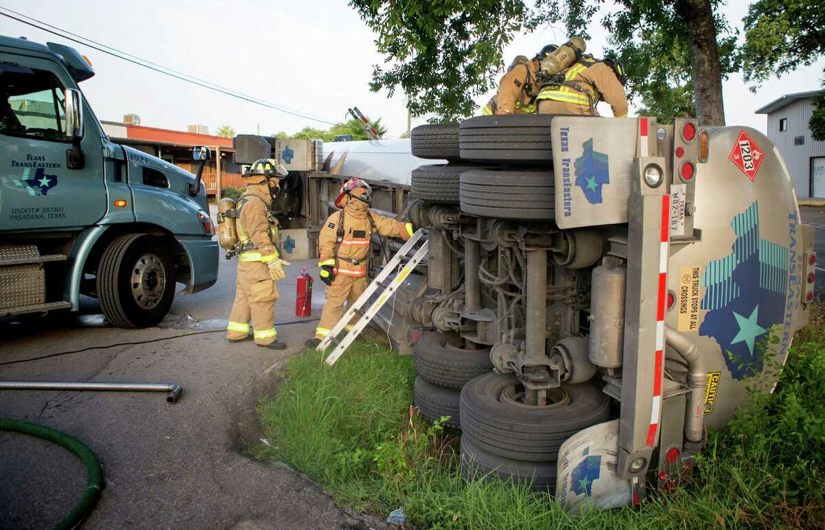 Firefighters work the scene of an overturned big rig wreck in the 1200 block of Parker near Nett, Friday, July 11, 2014, in Houston. Hazmat units were dispatched to the wreck to help crews clear the scene. (Cody Duty / Houston Chronicle)