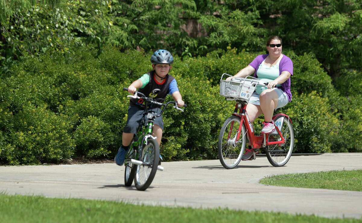 Crystal Humble, of Douglas, Ariz., rides a B-Cycle during an outing with her son, Landen Humble, 8, in Hermann Park on July 11, 2014, in Houston. The B-Cycle location at Hermann Park Lake Plaza, 6100 Hermann Park Drive, near the zoo is the city's most popular spot for picking up the recognizable bikes.