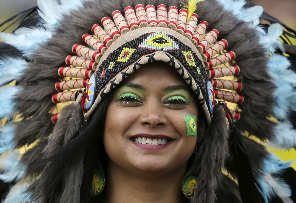 A Brazil soccer fan wearing a headdress poses for a photo as she makes her way to Mineirao Stadium to see the semifinal World Cup match between Brazil and Germany in Belo Horizonte, Brazil, Tuesday, July 8, 2014. (AP Photo/Bruno Magalhaes)
