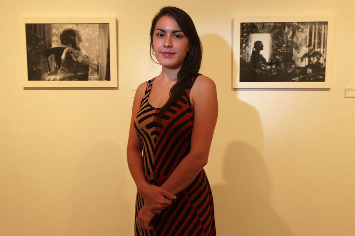 Janelle Esparza poses with her work on exhibit at the Blue Star Contemporary Art Museum, Thursday, July 3, 2014. Esparza is a photographer who used multiple exposure on her negatives to create her photographs for 'Ancestral Archetypes'.