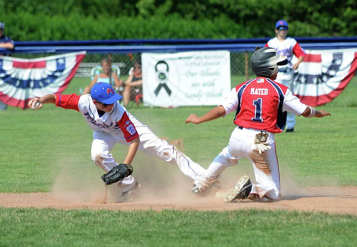 North Stamford's Connor Rondano tries to hold onto the ball as Norwalk's runner Randy mateo is called out at second during Saturday's District 1 Little League Championship game at Frank Noto Field at West Beach in Stamford, Conn., on July 12, 2014.