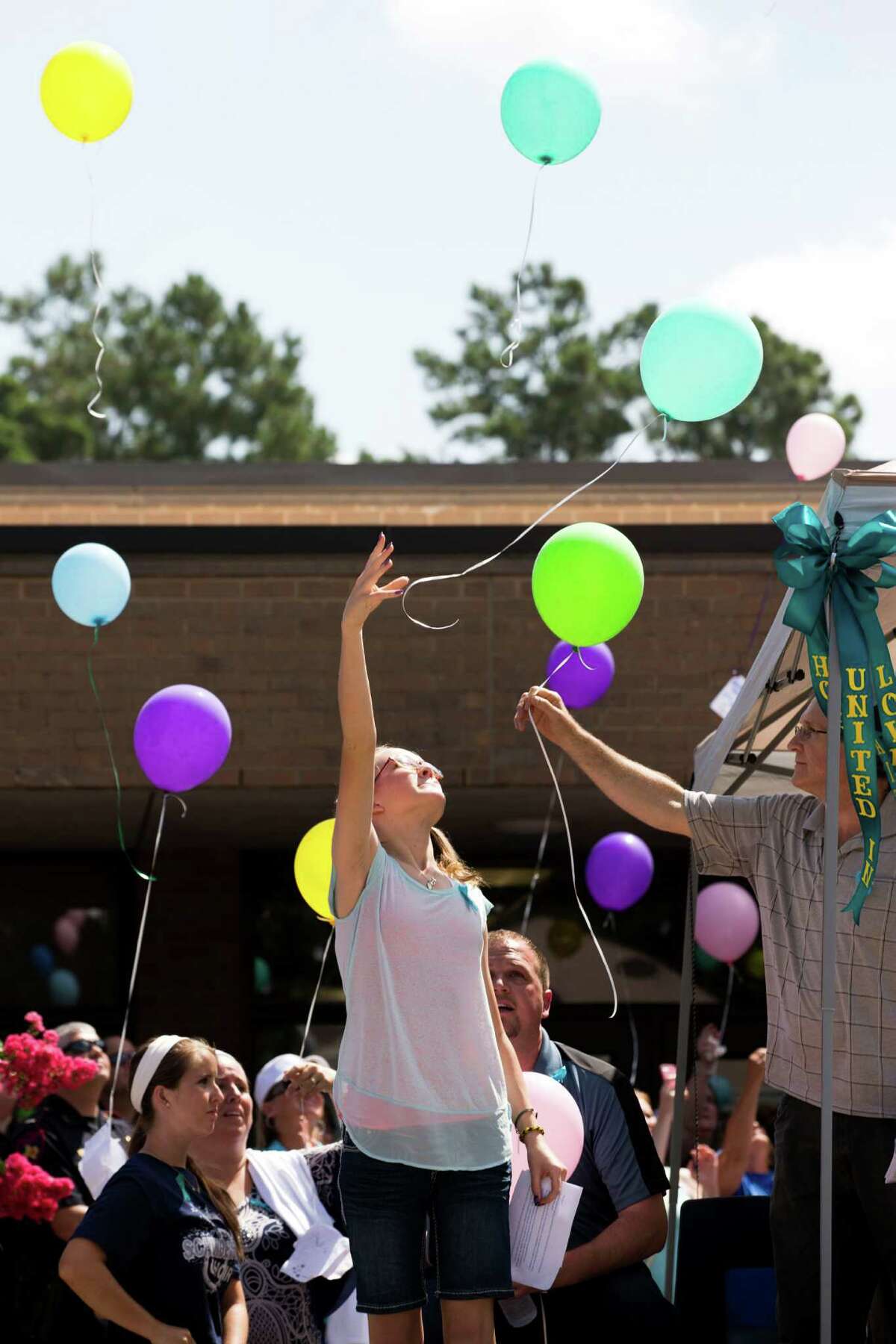 Cassidy Stay, lone survivor of the mass shooting of her parents and siblings, lets a balloon go during a community memorial ﻿for the Stay family﻿.