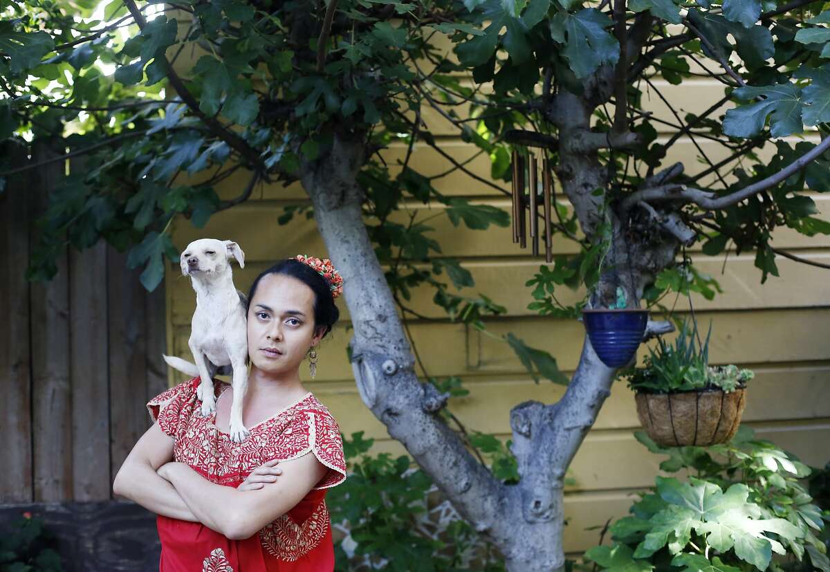 With his dog Cali on his shoulder, artist Jean Franco Pilas honors Frida Kahlo in his San Francisco back yard.