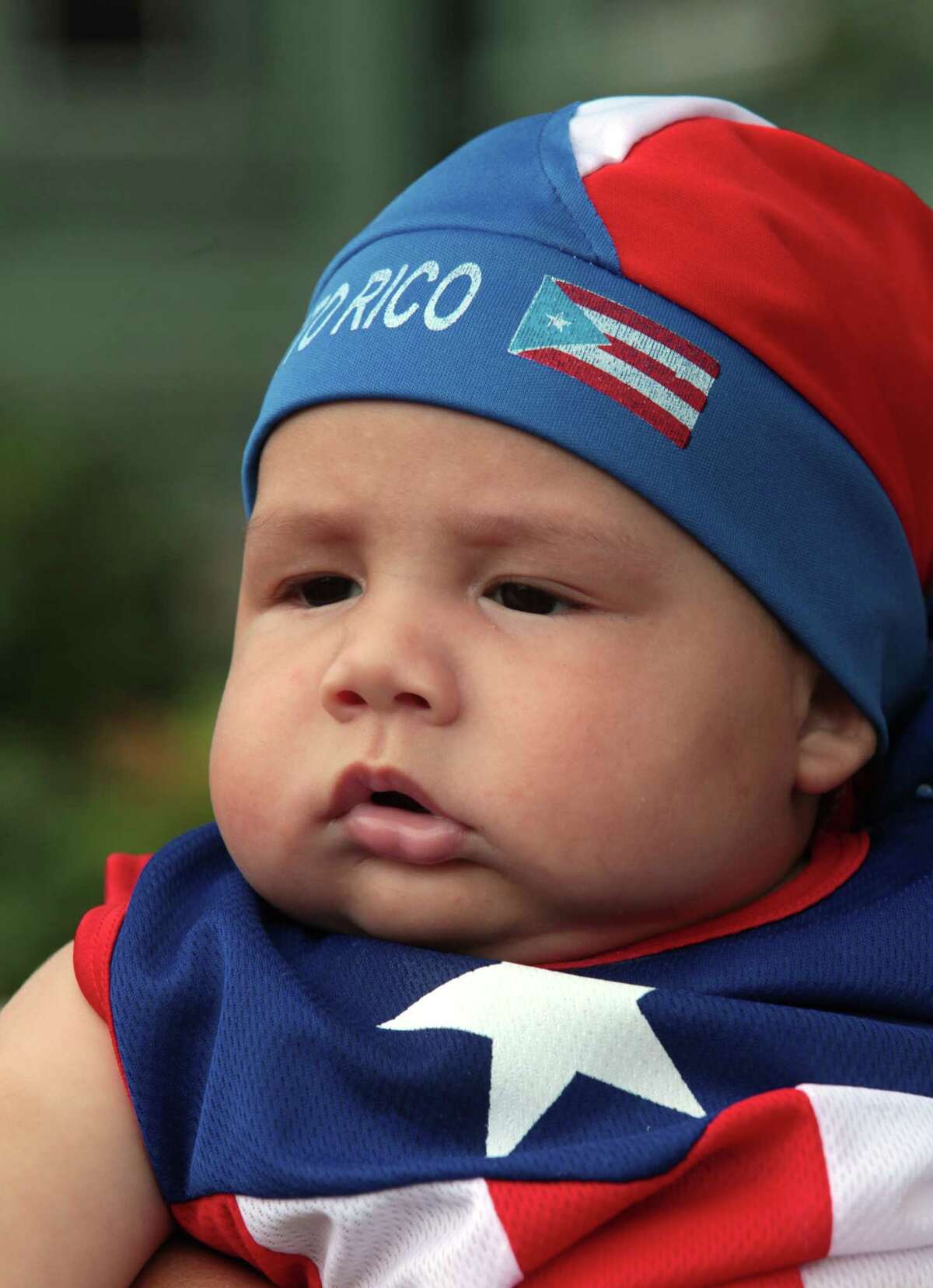 Joshua Perez, 4 mos, of Bridgeport, watches the annual Puerto Rican Parade of Fairfield County in Bridgeport, Conn. on Sunday, June 13, 2014.