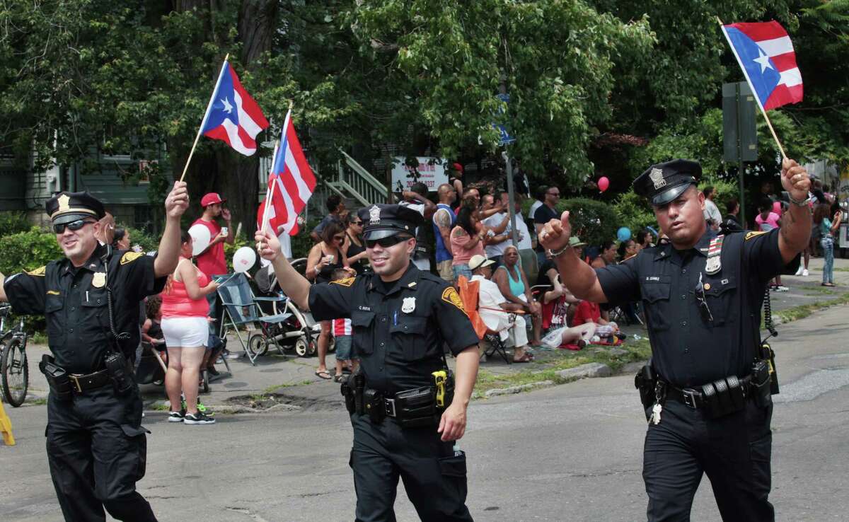 Bridgeport Police officers, from left, Sargent Joseph Hernandez, Carlos Pabon, and Danny Gomez, Jr., march in the annual Puerto Rican Parade of Fairfield County in Bridgeport, Conn. on Sunday, June 13, 2014.