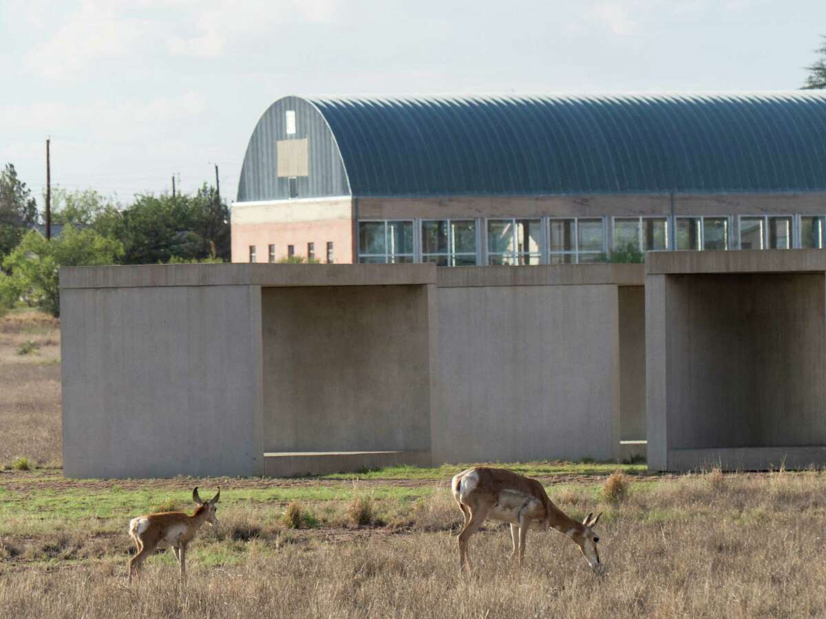 Pronghorns graze by Donald Judd's sculptures in Marfa, the West Texas town that's attracting the affluent, who are driving home prices and property taxes out of reach for many.