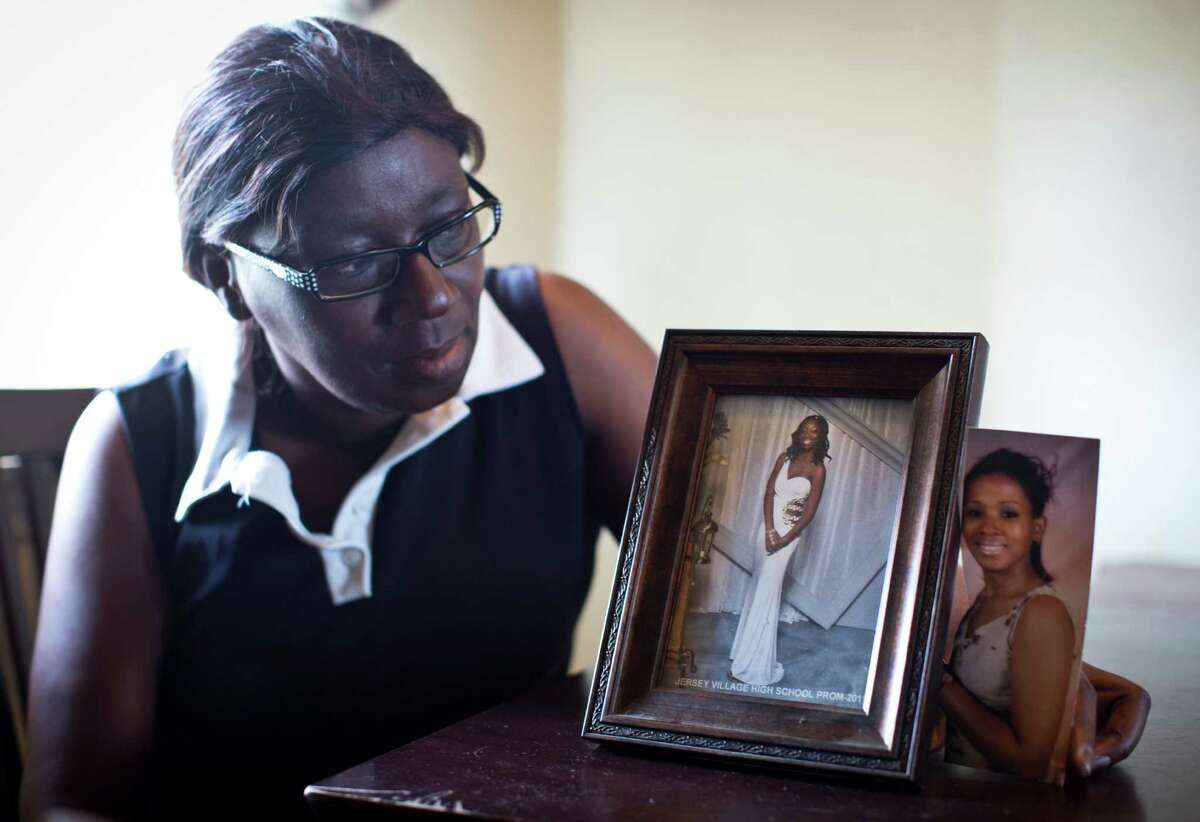 Ronda Madison sits by a photograph of her daughter and sister, Rachel Prado, who were both murdered by Prado's ex-husband.